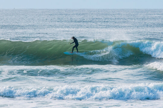 Surfer riding powerful ocean wave with surfboard