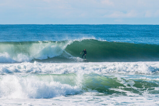 Surfer riding an ocean wave during a sunny day