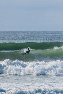 Surfer riding powerful ocean wave on surfboard