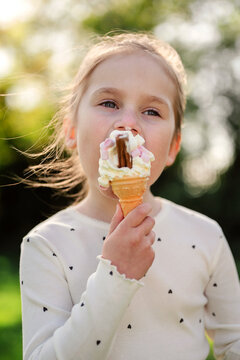 Little girl eating ice cream outdoors, summer time