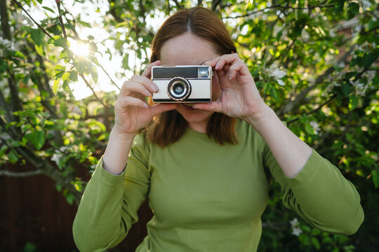 Close-up of vintage camera held by woman outdoors