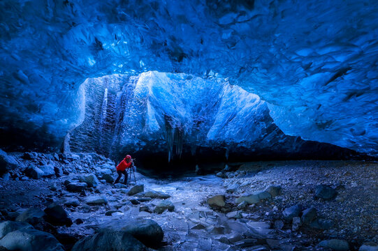 Solo female adventure traveler is discovering the ice caves in Iceland