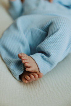 Blue Onesie Newborn Baby Feet Close Up Cozy In Home Lifestyle