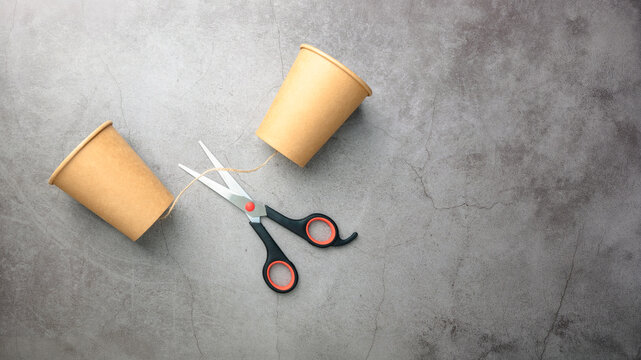 Broken communication and social disconnection concept with cut string phone