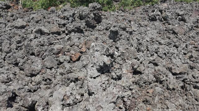 Porous basalt rock texture in closeup, spongy volcanic stone surface background. Vesicular lava material detail, pumice geology pattern for rugged mineral backdrop.