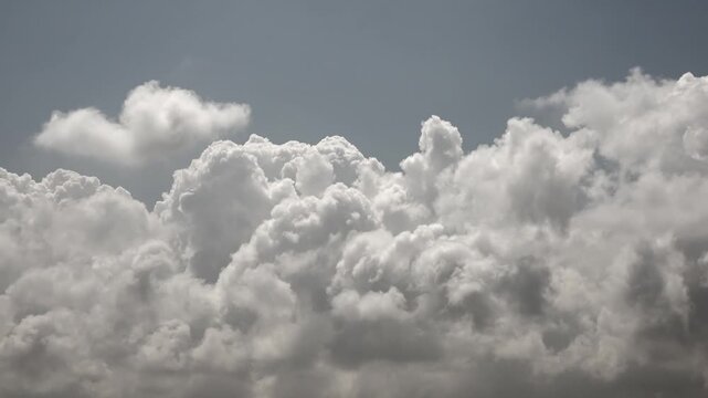 Time lapse fluffy clouds drifting across bright blue daytime sky in humid weather. Rapid cloudscape motion soft cumulus masses gliding through sunlit atmosphere and warm air.