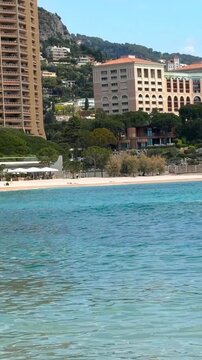 A girl in a dress walks along the beach in Monaco, Monte Carlo