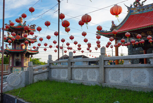 Scenic view of a Chinese temple complex decorated with festive lanterns under a blue sky.