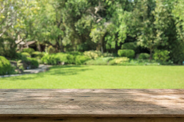 Naklejka premium Empty wood table top with abstract blur park garden background