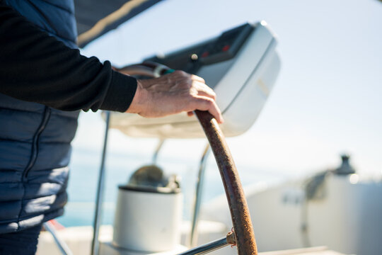 Hand steering sailboat wheel on ocean voyage
