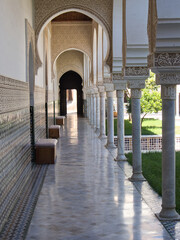 Obraz premium Ornate Moorish arcade corridor with marble columns, intricate stucco arches and zellige tilework in Islamic palace, Tlemcem, Algeria
