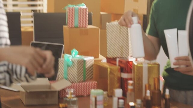 Young beautiful Asian girl reviewing cosmetic and skin care product with new collection's promotion selling on social media online live blurred phone screen surrounded beauty merchandise. Stratagem.