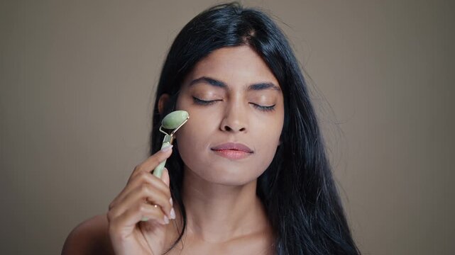 Young woman enjoys a relaxing face massage with a jade roller gua sha