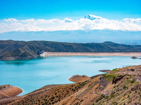 Vast reservoir with dam, surrounded by arid hills