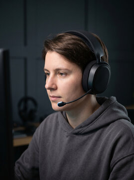 Focused Person Wearing A Headset And Hoodie Looking At A Screen