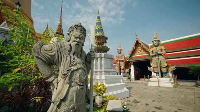 Stone guardian warrior statue at Wat Phra Kaew in Bangkok with colorful temple architecture and giant demons in Thailand