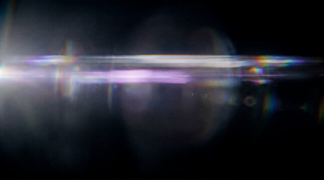 Abstract optical anamorphic lens flare horizontal light streak bright glowing reflection dark background cinematic overlay effect beautiful futuristic neon purple blue illumination
