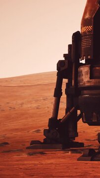 A robotic leg stands on the surface of Mars. The red terrain stretches in the background under a bright sky. This shows the technology used for exploring new worlds.