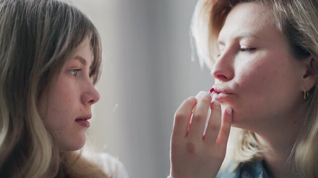 Professional makeup artist applying lipstick to a model