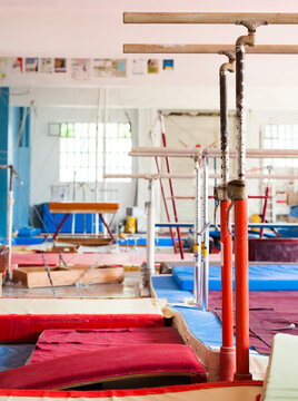 Interior of gym with old exercise machines, parallel bars and pommel horse