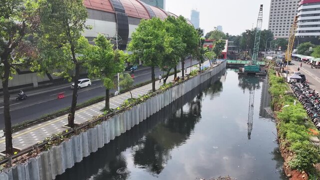 Sustainable Urban Planning for Future Cities Aerial view of bridge foundation construction on a river, featuring heavy steel sheet piling, concrete reinforcement, and a tall tower crane on a cofferdam