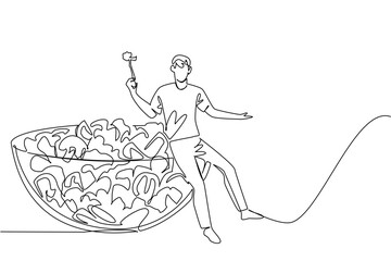 Single line drawing of cute man sitting on huge glass bowl of flying fresh healthy raw vegetable salad. Organic agriculture concept for National Eat Your Vegetables Day community event flyer visual