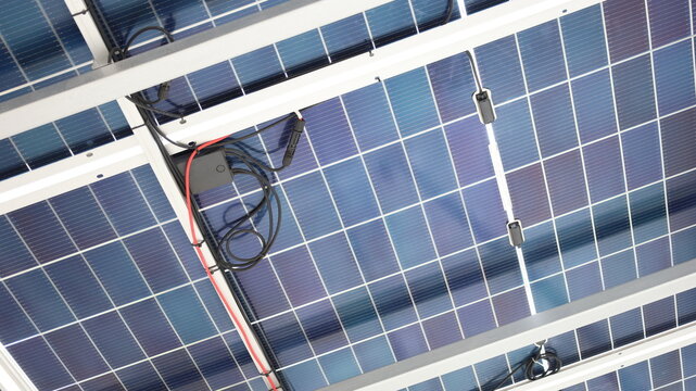 Solar junction box. Black PV junction box of diode blocks under solar panels in clean energy roof garage with copy space with selective focus.