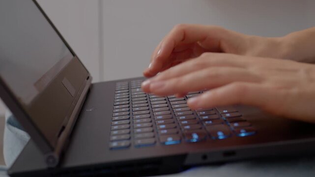 Fingers glide across a laptop keyboard, creating a rhythmic sound. The setting is relaxed, with soft lighting enhancing the comfortable atmosphere.