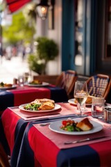 Fototapeta premium Table set at outdoor terrace of french cafe with wine and salad. Bistro catering at city street. Breakfast or lunch service in urban restaurant interior. Travel and vacation concept.