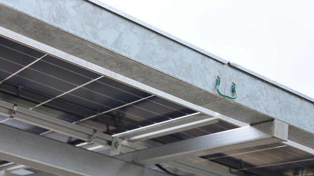 Ground Bonding for cable tray. Close-up of ground bonding for aluminum cable tray for safety of solar panel electrical system in bottom view with selective focus.