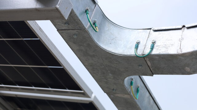 Ground Bonding for cable tray. Close-up of ground bonding for aluminum cable tray for safety of solar panel electrical system in bottom view with selective focus.
