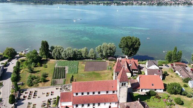 Panorama flight over church Basilica of Sts. Peter and Paul on island Reichenau towards Lake Constance (Bodensee) near Konstanz, Germany