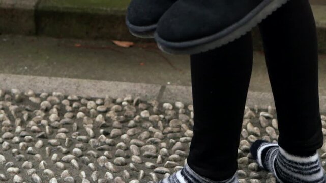 A person walks in socks on the unique Health Path with stones and logs at Kawagoe Kumano Shrine in Japan designed for health and circulation in winter.