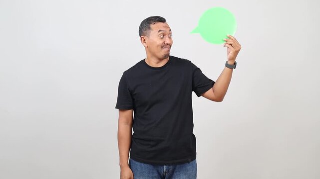 Asian man holding speech bubble over isolated white background with a happy face standing and smiling with a confident smile