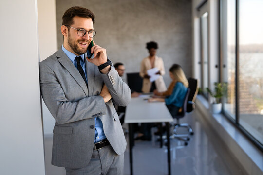 Confident businessman in modern office wearing suit and tie, showcasing executive leadership