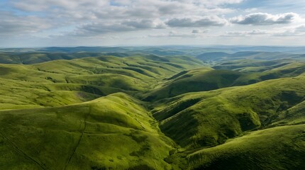 Obraz premium Expansive Green Rolling Hills Under a Partly Cloudy Sky, Scenic Landscape View