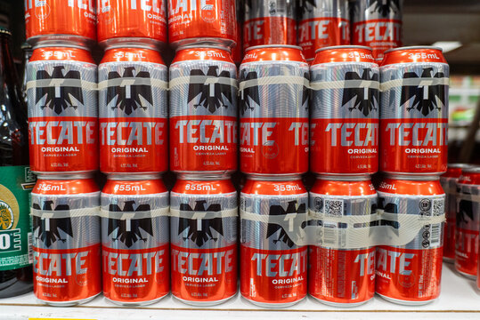 Villa de Alvarez, Colima. Mexico. April 14, 2026: Red and Silver Cans of Tecate Lager Beer Stacked in a Retail Display