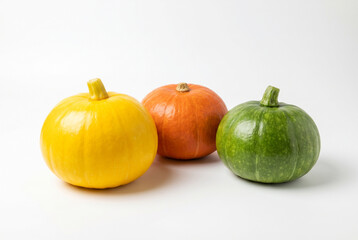 Obraz premium Yellow orange and green autumn squashes grouped on white background