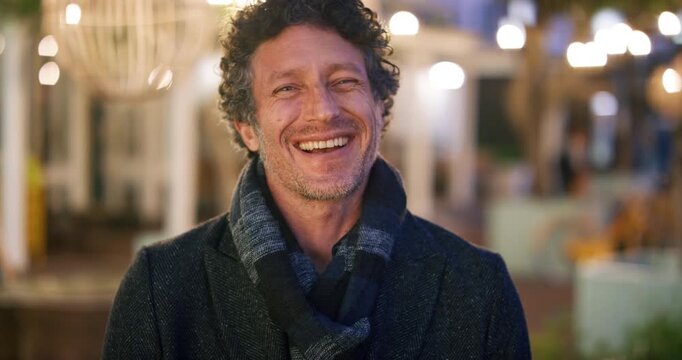 Happy man, face or night with laugh in city for travel, outdoor commute or tourism on bokeh. Mature person, traveler or tourist with smile in evening for fun location or destination in urban town
