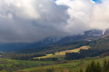 Fototapeta premium Dramatic clouds of the autumn Carpathian mountains at early morning in the sunrise.