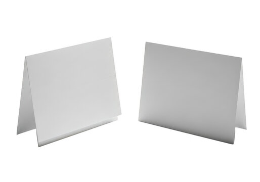 Two empty white paper table tent cards standing on a flat surface isolated on transparent background