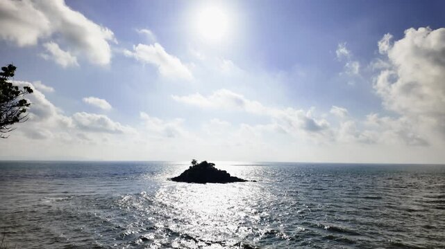 At Cong vien Nginh Phong in Vung Tau, Vietnam, visitors enjoy views of the ocean and a small island. People stroll along paths and take in the natural surroundings during the day.