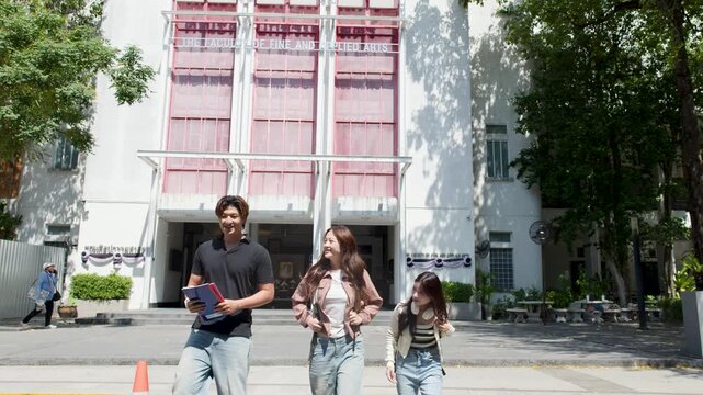 Three Asian University Students Walking and Talking on Campus Outdoors