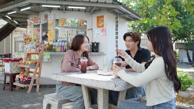 Asian University Students Socializing at an Outdoor Campus Cafeteria in Thailand