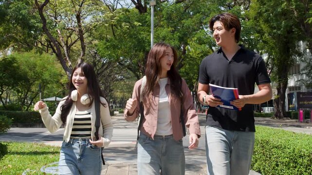 Three Asian University Students Walking and Talking on a Sunny Campus