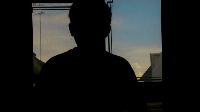 View through antique window frames at rooftop buildings and cloudy sky at dusk