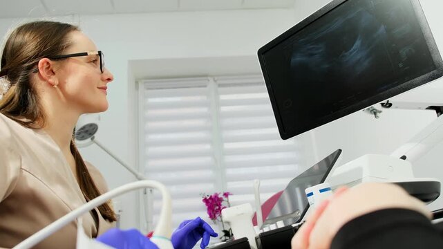 Specialist studies ultrasound display during pelvic diagnostic procedure. Gynecologist observes scan patterns verifying examination results