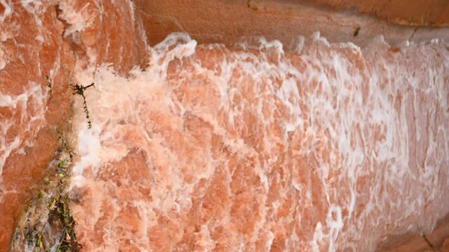 Abstract red water texture with foam patterns and swirling waves, natural background surface with copy space. Abstract orange-red texture from an iron and steel manufactory, molten metal or industrial