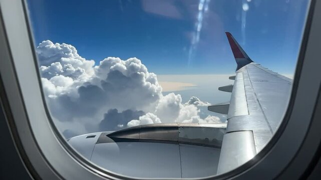 Scenic view of puffy white clouds and aircraft wing soaring through a bright blue sky on a sunny day