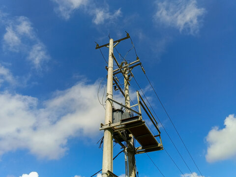 An electrical power transformer mounted on a utility pole.